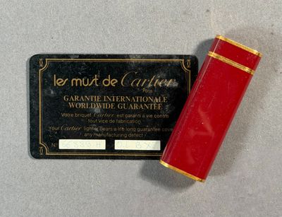 CARTIER MUST. Briquet en métal doré et émaillé rouge.