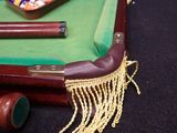 a miniature pool table with a pool cues and a pool ball on it