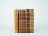 quatre vieux livres empilés les uns sur les autres sur une surface blanche
