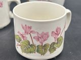 two cups with flowers painted on them on a table