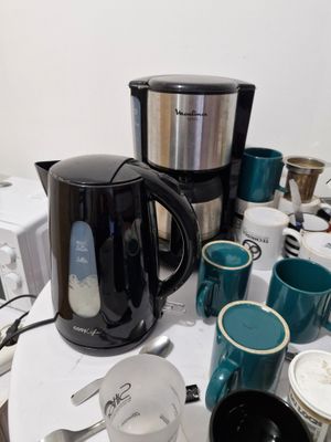 une table couverte de tasses à café et de bouilloires