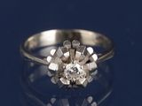 un gros plan d'une bague en diamant posée sur une surface bleue