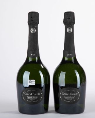 deux bouteilles de champagne posées l'une à côté de l'autre sur une surface blanche