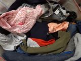 a pile of clothes in a suitcase on the floor