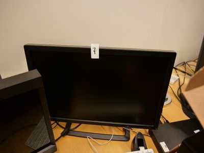un écran d'ordinateur posé sur un bureau, à côté d'un ordinateur portable