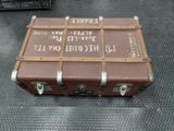 a brown suitcase with writing on it sitting on the floor
