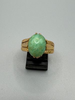 l'image d'une bague en or contenant une pierre verte