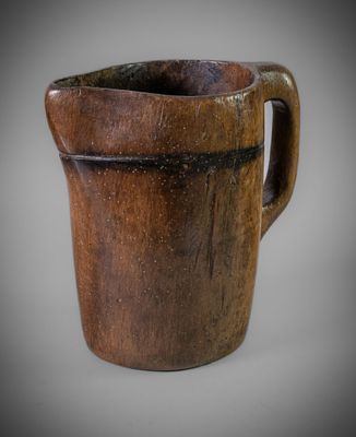 an image of a wooden cup with a handle on a gray background