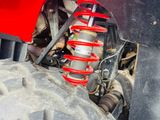 a close up of a red atv with a big tire