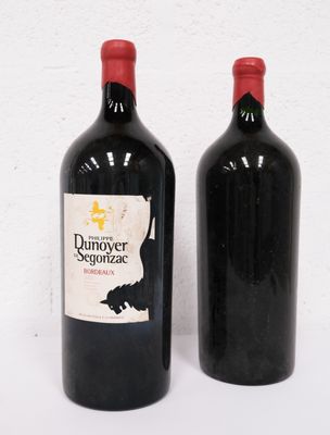 two bottles of wine sitting next to each other on a white surface
