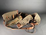 two pairs of leather and canvas holsters on a gray background