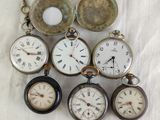 many different types of pocket watches sitting on a table