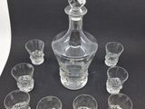 an image of a glass decanter and six shot glasses on a table