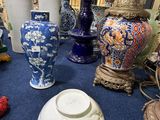 de nombreux vases et autres objets décoratifs posés par terre