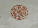 a white plate with a red stamp on it