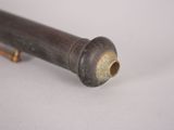 a metal pipe with a wooden handle on a white surface