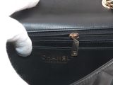someone is holding a black purse with a white glove on top of it