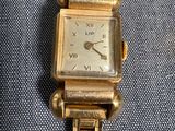 une image d'une montre-bracelet en or avec des chiffres romains