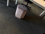 un tabouret rose posé devant un bureau sur lequel se trouve un ordinateur