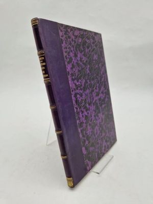a purple book with gold trim sitting on top of a white surface