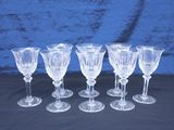 six verres à pied en verre transparent sont alignés sur une table