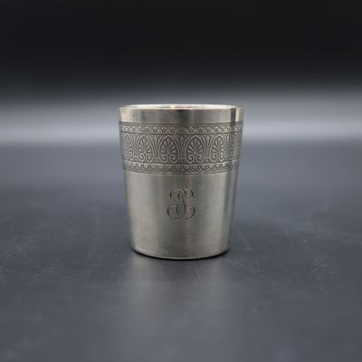 a close up of a silver shot glass on a table