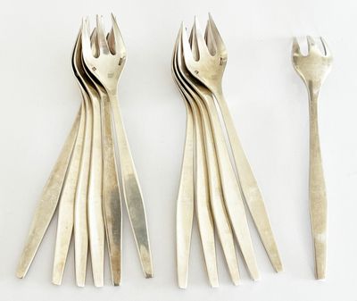 quatre fourchettes et deux cuillères sur une table blanche