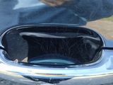reflection of a man in a car ' s rear window with a baseball glove on it