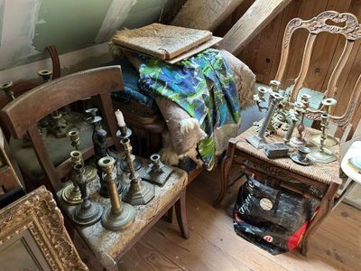 un tas d'antiquités posées sur une chaise dans un coin de la pièce