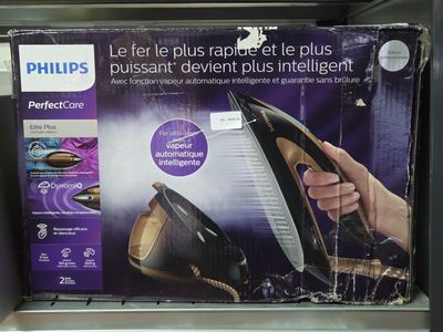 une boîte sur laquelle figure l'image d'une personne tenant un fer à repasser à vapeur noir et doré