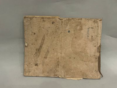an old book sitting on top of a table covered in dirt