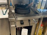 une cuisinière sur laquelle est posée une marmite dans une cuisine