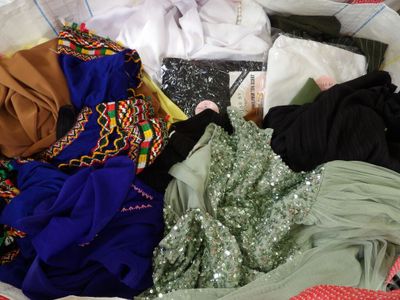 a pile of clothes that is sitting on a bed