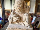 a statue of a woman sitting on top of a table