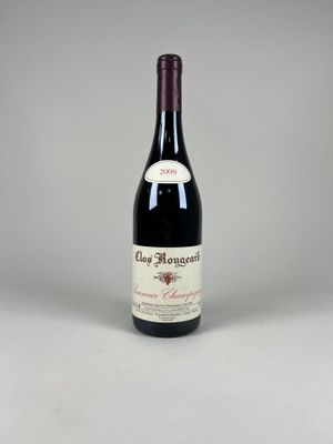 une bouteille de vin rouge posée sur une table blanche