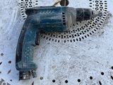 une perceuse posée sur une table recouverte d'un napperon