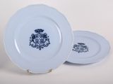 three blue and white plates with a coat of arms and a coat of arms on them