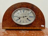 une horloge en bois avec des chiffres romains, posée sur une table