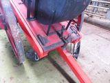 a red trailer with a large black object on it