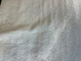 a close up of a white blanket on a bed