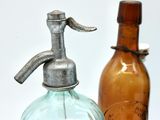 two old glass bottles next to each other on a table