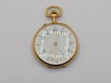 a gold pocket watch with a white face on a white surface