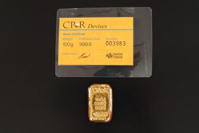un gros plan sur un lingot d'or auquel est attachée une carte de crédit