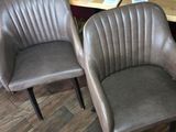 three brown leather chairs sitting in front of a wooden table