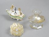 three pieces of glass on a table with a boat on top of it