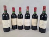 six bouteilles de vin sont alignées sur une table