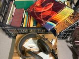 des livres et un casque audio posés sur un bureau où se trouvent une horloge et un téléphone