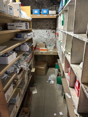a narrow room with lots of boxes and boxes on the shelves