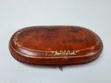 an image of a brown leather case with a gold decoration