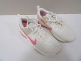 white and pink nike running shoes on a white surface